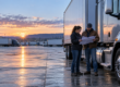 A dispatcher and driver reviewing a route map beside a tractor at a regional trucking terminal