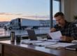 A trucking owner carefully reviewing an insurance notice and payment records in a quiet office